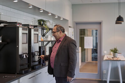 Man preparing coffee in office kitchen