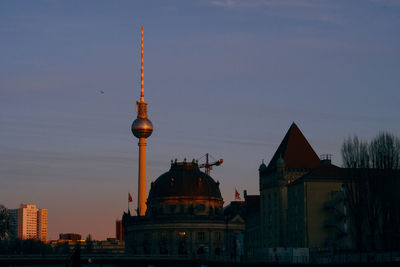 Buildings in city against clear blue sky