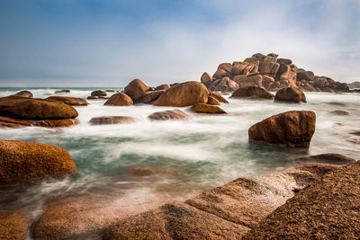 Rocks on beach against sky