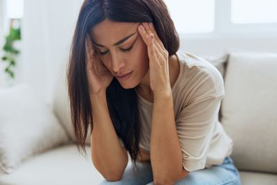 Young woman sitting on bed at home