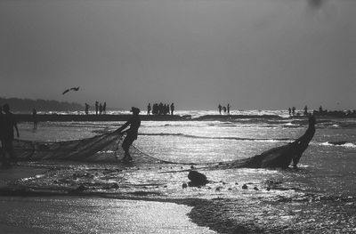 People at beach against sky