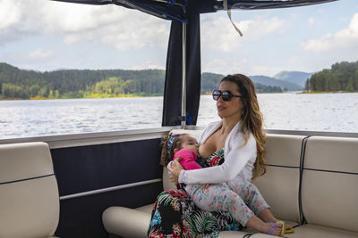 Beautiful woman sitting on boat in sea