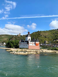 Castle by river against sky