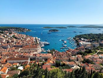 High angle view of townscape by sea against clear sky