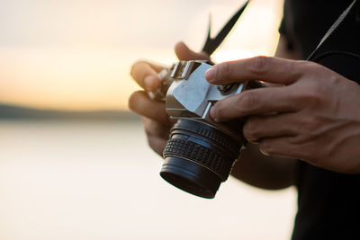 Midsection of man holding camera