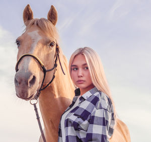 Portrait of woman with horse against sky