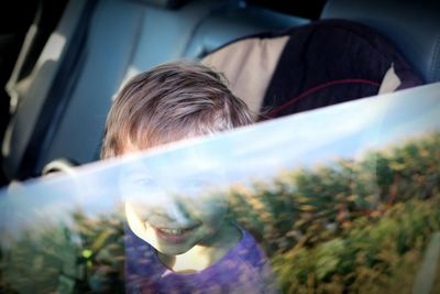 Portrait of cute smiling girl sitting in car