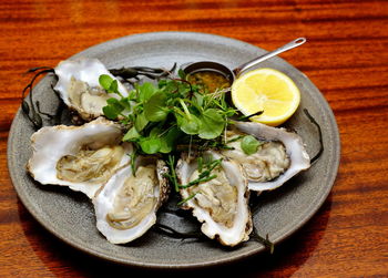 High angle view of oysters served on wooden table