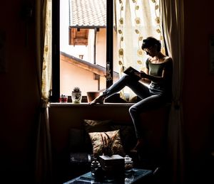 Woman sitting by window at home