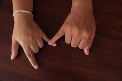 Close-up of woman hand on wooden table