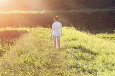 Rear view of woman on grass field