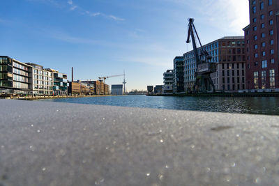 Surface level of river by buildings against sky