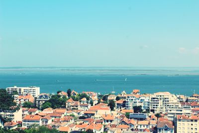 High angle view of townscape by sea against sky