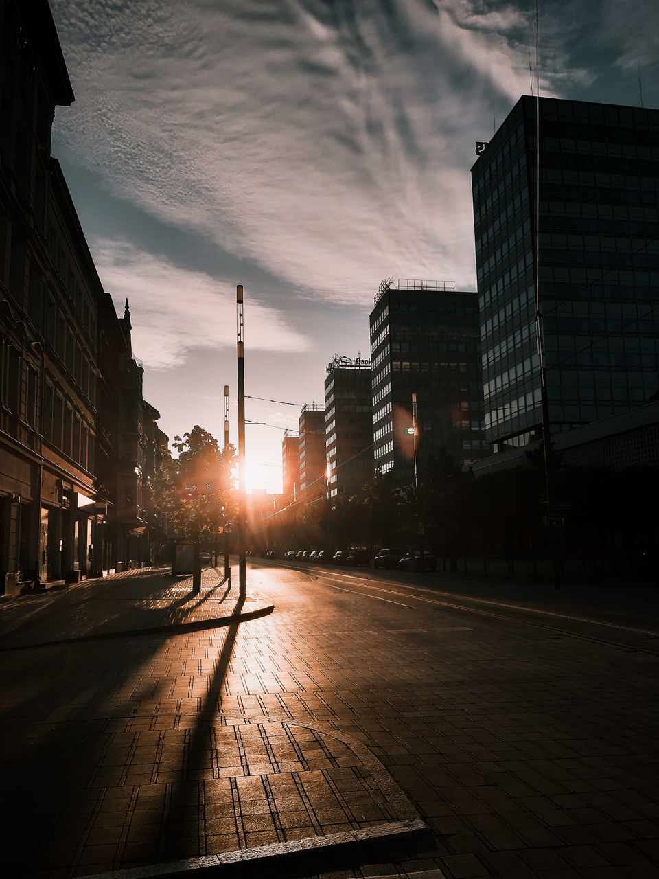 building exterior, architecture, sky, built structure, city, sunset, cloud - sky, building, street, nature, transportation, sunlight, no people, outdoors, office building exterior, residential district, road, city life, street light, city street, skyscraper