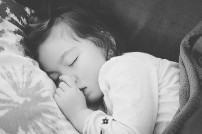 Side view of girl sleeping on sofa