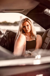 Portrait of beautiful woman sitting at car