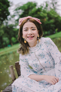 Portrait of smiling woman sitting on jetty