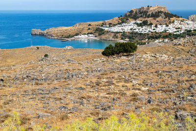 Scenic view at the city of lindos with white houses, the antique acropolis on top of the mountain