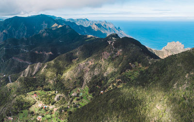 Scenic view of sea and mountains against sky