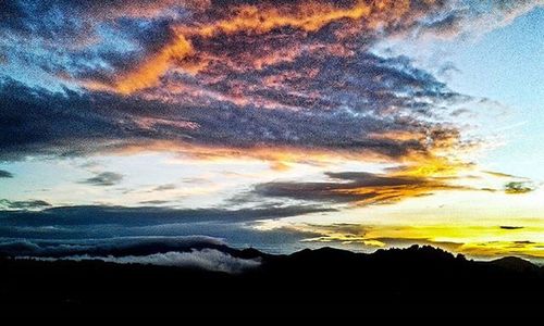 Scenic view of mountains against cloudy sky