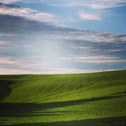 Scenic view of field against cloudy sky