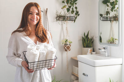 Portrait of beautiful young woman standing in bathroom