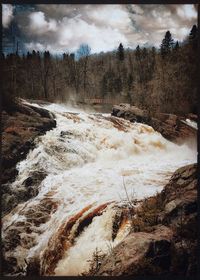 Scenic view of waterfall against sky