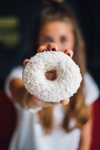 Close-up portrait of young woman holding ice cream