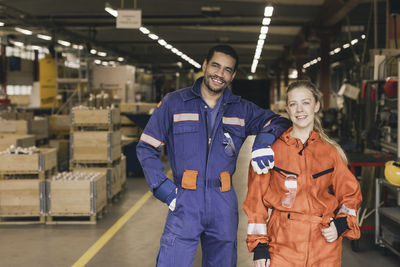 Portrait of smiling male and female coworkers in factory warehouse