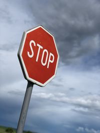 Low angle view of stop sign against sky