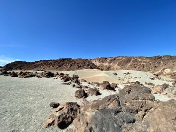 Scenic view of desert against clear blue sky