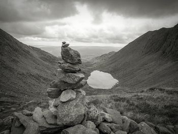 Stack of rocks by mountain against sky