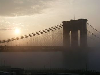 Silhouette suspension bridge against sky during sunset