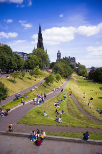 Tourists relaxing in the princess street gardens in edinburgh on a summer day