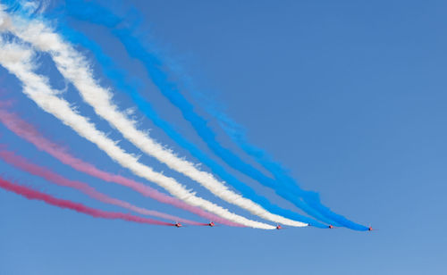 Low angle view of airplane flying against blue sky