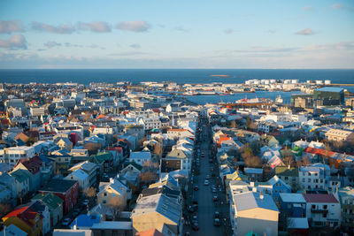 High angle view of town by sea against sky