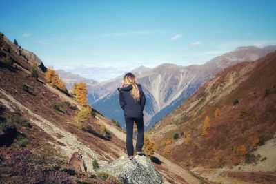 Woman standing on mountain against sky