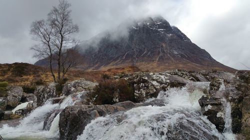 Scenic view of waterfall against sky