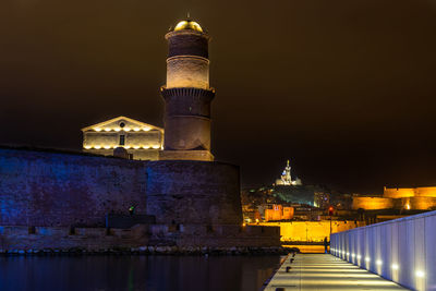 Night view of marseille old port with former lighthouse tower of fort saint-jean, france