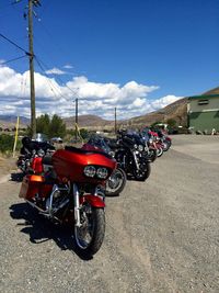 Motorcycles parked on street against blue sky