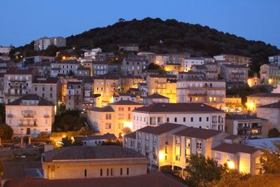 Illuminated town against sky at night