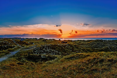 Scenic view of land against sky during sunset