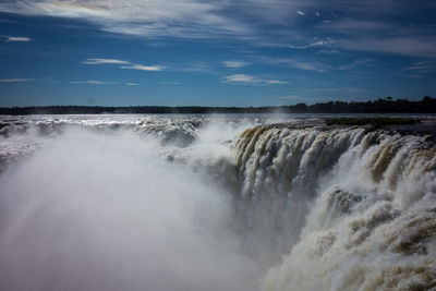 Scenic view of waterfall against sky