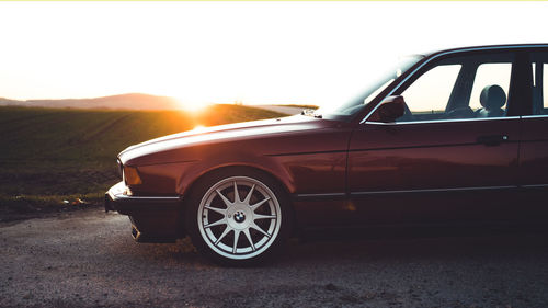 Vintage car on road against sky during sunset