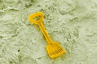 High angle view of yellow toy on sand