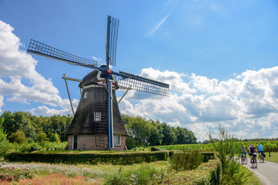 Traditional windmill on field against sky