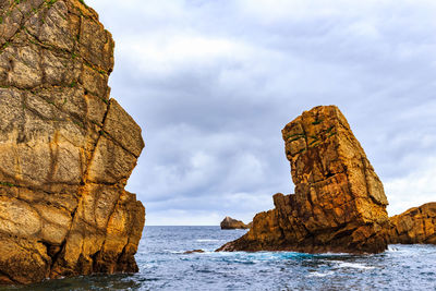 Scenic view of rock formation in sea against sky