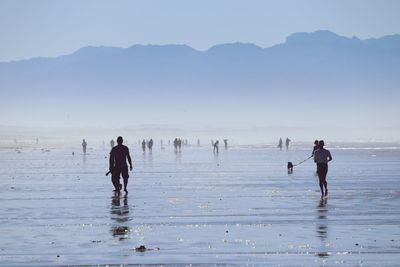 People on beach against sky