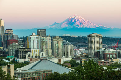 Buildings in city against sky during sunset