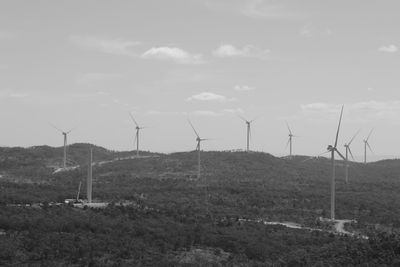 Windmills on field against sky